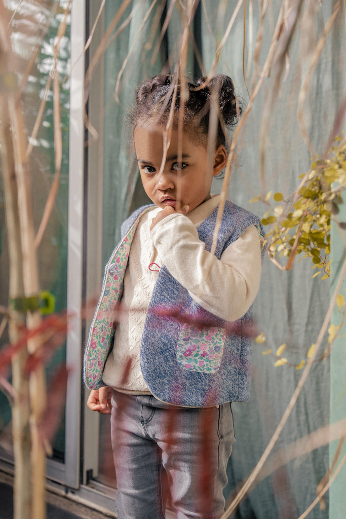 Gilet enfant Figue-Violette Azala, 100% recyclé et upcyclé, porté côté Figue, taille 3 ans. Shooting extérieur, showroom Azala.